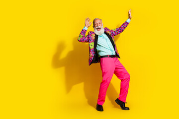 Full size photo of extravagant elderly man classy vibrant clothes dance empty space isolated on yellow color background