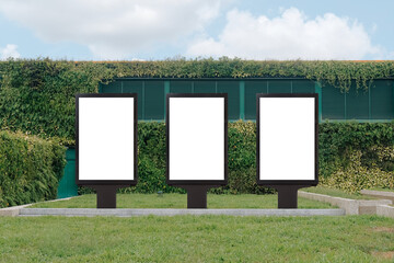 vertical mock up template: 3 out of home (ooh) advertising billboard posters on grass, against backg