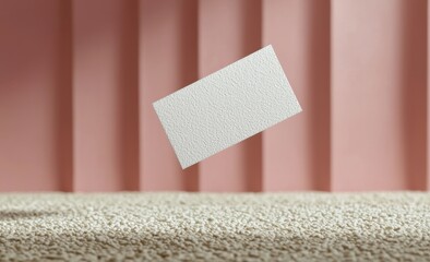 Wall Mural - Close-up photograph of an empty white card on textured surface with a soft pink background