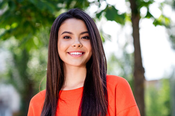 Photo of pretty teen good mood girl look camera toothy smile wear red clothes walk outside urban city park