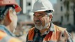 © Chandara - Experienced Hispanic construction worker in a hard hat giving instructions to a team.