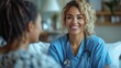 © TheGoldTiger - Smiling healthcare professional wearing scrubs and a stethoscope converses with a patient in a room, conveying a comforting atmosphere