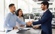 © Prostock-studio - Smiling middle-eastern young man and woman buying car at auto salon, handsome arab guy shaking sales assistant hand, making successful deal, happy family got brand new luxury car, side view