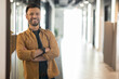 © Prostock-studio - Successful Entrepreneurship. Happy Businessman Smiling To Camera Posing Crossing Hands Standing In Doorway Of Modern Office. Employment And Business Career Concept