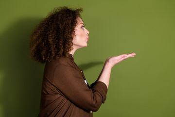 Poster - Profile portrait of pretty young girl send air kiss empty space wear brown shirt isolated on khaki color background