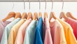 © adVance - close up a collection of pastel color t-shirts hanging on a wooden clothes hanger in closet or clothing rack over white background