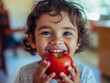 © Mattie - child eating apple with a big smile to have a healthy after school snack. Preschool toddler nutrition eat. Enjoy. Cute. Curly hair. Hispanic. Diverse