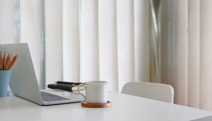 Modern workplace with laptop computer, coffee cup and office supplies