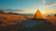© CreativeIMGIdeas - A yellow teepee is set up in a field with a beautiful sunset in the background. The scene is peaceful and serene, with the sun setting behind the teepee, casting a warm glow over the area