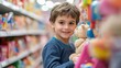 © Ilmi - portrait smiling kid standing in a toy store. A boy is choosing toys in a toy store.