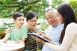 © DG PhotoStock - Multi generation Asian family relaxing in backyard garden together.