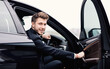 © Prostock-studio - Confident Chauffeur. Guy in suit sitting in driver's seat, getting in his car at downtown area, closing the door