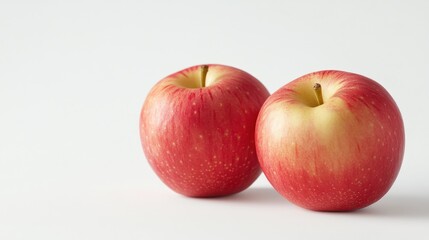 Poster - Two red apples on a white background, showcasing their vibrant color and fresh appearance.