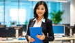 © vstudio - beautiful young professional asian woman holding blue folder in modern office setting with computers in background