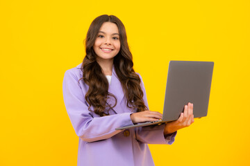 Wall Mural - Young girl student hold computer. Funny pupil with laptop isolated on yellow background. Back to school.