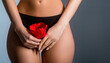 © Yevhen - Gynecology. Woman in underwear with flower on gray background, closeup. Fit woman in black underwear holding red flower. Menstruation and gynecology concept