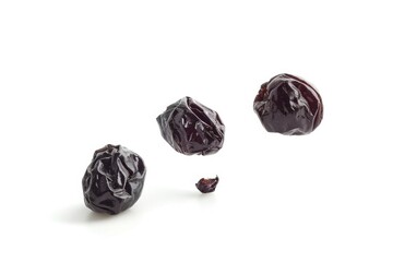 Poster - A group of dried plums sitting on a white surface, great for food or still life photography