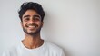 © eko - Happy young man with dark hair smiling against a white background.