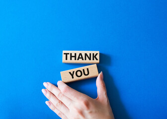 Wall Mural - Thank you symbol. Wooden blocks with words Thank you. Businessman hand. Beautiful blue background. Business and Thank you concept. Copy space.