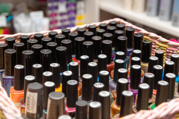 Bottles of coloured nail polish in a box in beauty store.