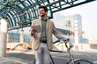 © Dorde - Smiling Businessman with Tablet by Bicycle in Urban Setting