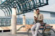 © Dorde - Smiling Businessman with Bicycle Using Smartphone Outdoors