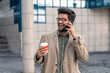 © Dorde - Energetic Businessman Engaged in Phone Call with Takeaway Coffee