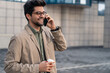 © Dorde - Energetic Young Businessman on Smartphone with Coffee