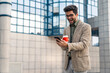 © Dorde - Enthusiastic Young Businessman with Smartphone and Coffee