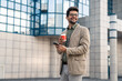 © Dorde - Joyful Businessman with Smartphone Enjoying Coffee Break Outdoors