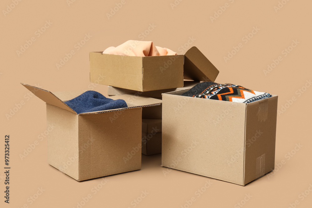 Wardrobe boxes with clothes on beige background