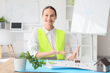 Poster - Female engineer with wind turbine model at table in office