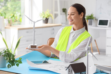 Poster - Female engineer with wind turbine model at table in office