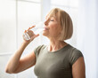 © Prostock-studio - Fit senior woman drinking clear water during her workout break at home. Mature Caucasian lady staying hydrated after sports training. Healthy lifestyle and wellness concept
