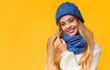 © Prostock-studio - Pretty blonde girl in blue winter hat smiling at camera over pink background, copy space