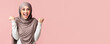 © Prostock-studio - Joy Of Victory. Happy Muslim Woman in Hijab Shaking Fists Celebrating Success Over Pink Studio Background, Empty Space