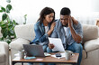 © Prostock-studio - Family Financial Crisis Concept. Depressed Black Couple Looking At Invoice, Not Able To Pay Huge Bills, Suffering From Coronacrisis At Home