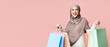 © Prostock-studio - Big sales. Joyful muslim girl in hijab holding lot of bright shopper bags happy after successful shopping, posing over pink background with free space