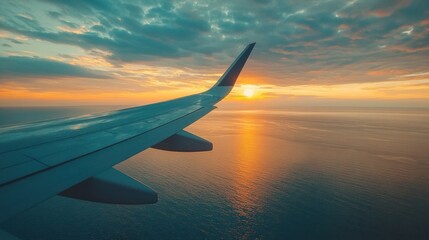 Wall Mural - Airplane wing with golden sunset reflecting on the water.