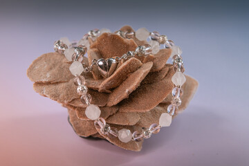 Wall Mural - Light pink and white quartz necklace with a metallic heart on a desert rose stone on gradient