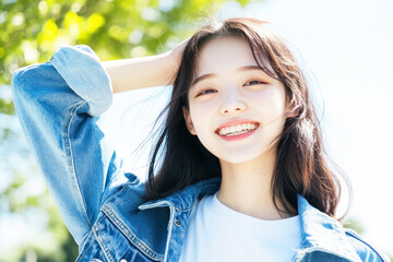 Korean woman in casual shirt smile arm on head at sunny park