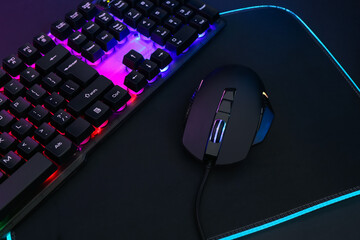 Wall Mural - Computer mouse, mousepad and RGB keyboard on dark background, closeup