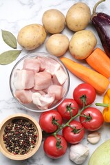 Wall Mural - Uncooked ingredients for stew on white marble table, flat lay