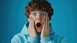 © DigitalMagicVisions - Surprised Teenage Boy in Sky Blue Hoodie with Hands on Face