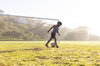 © WavebreakMediaMicro - Outdoors, playing soccer on field, young african american boy kicking ball near goalpost