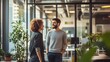 © sungedi - Two colleagues smiling and conversing in a modern office