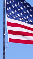 Wall Mural - us flag on a flagpole blowing in the breeze.