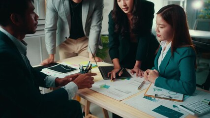 Fototapete - Group of four asian businesspeople are having a meeting in a modern office. Two women are explaining data analysis to their colleagues