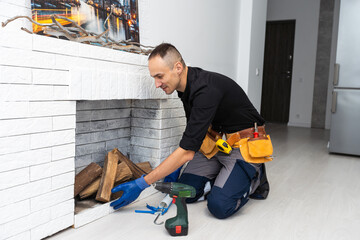 Worker building brick stove or fireplace checking it with spirit level