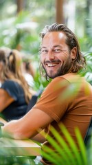 Wall Mural - A man smiles brightly while sitting outdoors. AI.